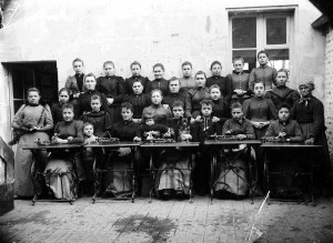 Les ouvrières de la fabrique de fleurs et Mme Bouthaud, la chef d’atelier, debout à gauche, vers 1900.